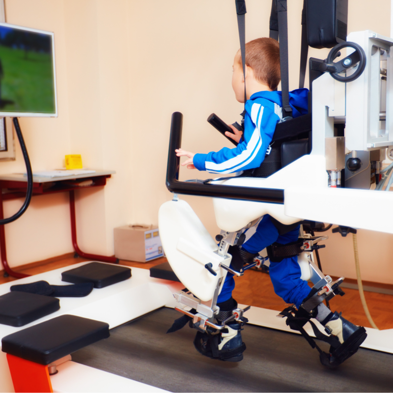 Young boy on gait training machine