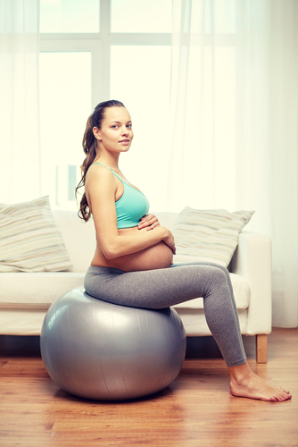 pregnant woman practicing posture on exercise ball