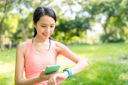 woman comparing phone and smartwatch