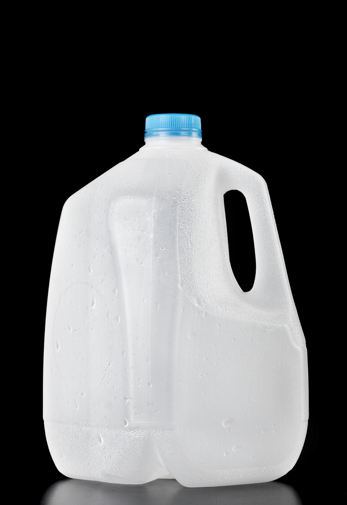 Gallon plastic water jug on black background