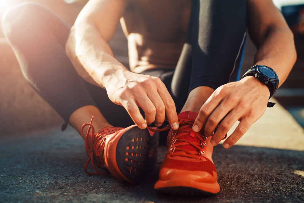 Man Exercising and Putting on Running Shoes