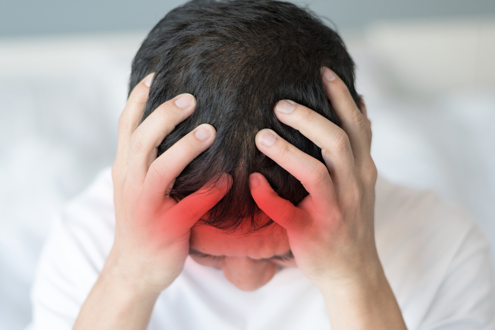 Young Man holding Head in Pain