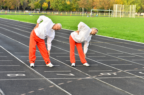 elderly people stretching on track