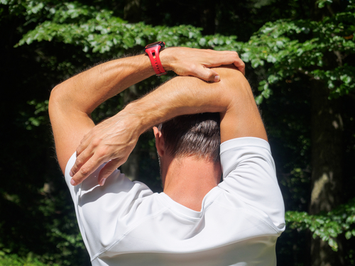 man doing triceps stretch