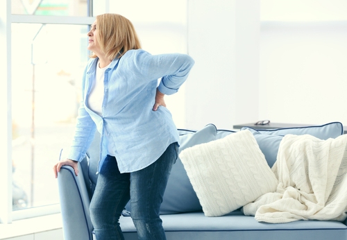 woman holding lower back in pain