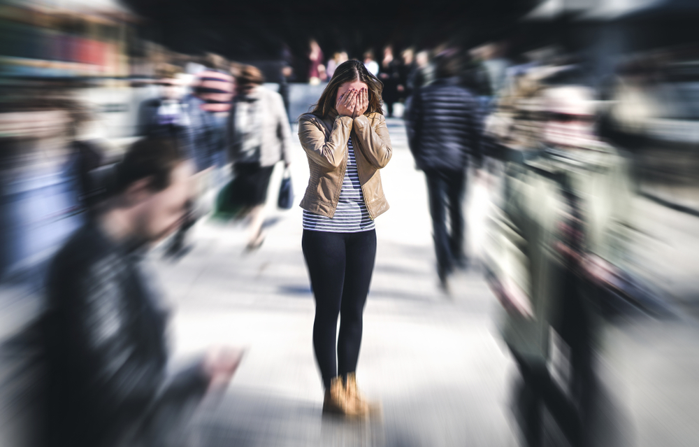 Panic attack in public place. Woman having panic disorder in city.